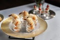 Shrimps wrapped in wheat thread and baked. Catering, beautiful table. Silver designer plate.