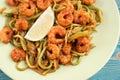 Shrimps and zucchini cut as noodles in green plate, close-up Royalty Free Stock Photo