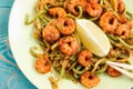 Shrimps and zucchini noodles in green plate, close-up Royalty Free Stock Photo