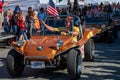 Shriners in gold dune buggy in small town during Applefest parade
