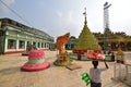 Shrines at Shwemawdaw Pagoda with a vendor carrying cut watermelon on the head