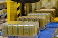 Shrink wrapped pack of aluminium beer cans on conveyor belt at brewery plant