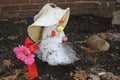 Shrinking melted snowman in a hat and flower