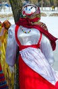 Shrovetide doll in colorful headscarf and sarafan outdoors