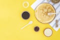 Shrovetide Maslenitsa Butter Week festival meal. Russian pancakes with butter, honey and jam on a yellow background. Top view,