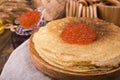 Shrovetide Maslenitsa Week festival meal. Stack of russian pancakes with red caviar. Rustic style, free space for text. Royalty Free Stock Photo