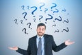 Shrugging shoulders businessman, question marks Royalty Free Stock Photo