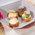 Shu cake choux. Cake profiteroles with whipped cream dessert in a box to go. Royalty Free Stock Photo