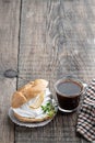 Shu cake profiteroles with whipped cream on rustic wooden table with lemon balm herb and cup of coffee Royalty Free Stock Photo