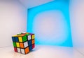 Shuffled Rubik`s Cube inside a cube with light blue background