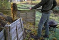 Shuffling compost for aeration and better rot. the gardener uses a shovel and pitchfork in his hand. He has green pants and a jack