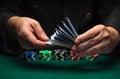 Shuffling of playing cards by the hands of a croupier or a dealer in a poker club. Casino game concept on green table with playing Royalty Free Stock Photo