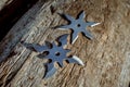 Shuriken throwing star, traditional japanese ninja cold weapon stuck in wooden background Royalty Free Stock Photo