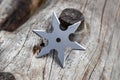 Shuriken throwing star, traditional japanese ninja cold weapon stuck in wooden background Royalty Free Stock Photo