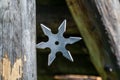 Shuriken throwing star, traditional japanese ninja cold weapon stuck in wooden background Royalty Free Stock Photo