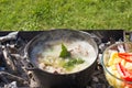 Shurpa soup in a large cast-iron cauldron outdoor. Summer food for hike. Royalty Free Stock Photo
