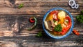 Shurpa soup in plate with oriental ornament, wooden background. Top view. traditional Asian, Uzbek, Middle East soup with beef or