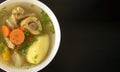 Shurpa soup in a white bowl on dark wooden background with copy space.