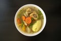 Shurpa soup in a white bowl on dark wooden background. Top view. Famous traditional Asian, Uzbek, Middle East soup with beef or la