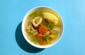 Shurpa soup in a white bowl on dark wooden background. Top view