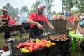 Cook prepares meal on the grill for sale in a summer cafe at the annual Intl festival `World of Siberia`FestMirSibiri.