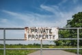 Shut and locked farm gate showing an improvised and rusting Private Property sign. Royalty Free Stock Photo