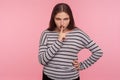 Shut up! Portrait of angry displeased woman in striped sweatshirt saying hush, be quiet with finger on lips