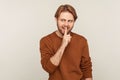 Shut up, stay quiet! Portrait of positive man wearing sweatshirt showing silence gesture with finger on lips