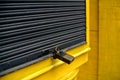 shutters of shops closed yellow and black with padlock Royalty Free Stock Photo
