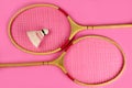 Shuttlecock and badminton rackets on a pink background Royalty Free Stock Photo