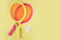 Shuttlecock and badminton rackets on a yellow background Royalty Free Stock Photo