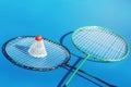 Shuttlecock or birdie on badminton racket on blue background. Sport concept. Royalty Free Stock Photo