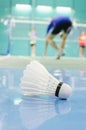 shuttlecock on the floor with badminton player Royalty Free Stock Photo