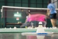 Shuttlecock resting on a badminton racket with badminton player are competiting