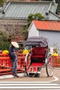 Shuzenji/Japan - 18 November 2019 : A rickshaw-puller man stands on historic street in front of Shuzenji temple wait for tourists