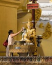 Burmese woman performing Buddhist ritual