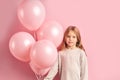 Shy beautiful girl kid holding pink air balloons isolated Royalty Free Stock Photo