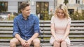 Shy blonde girl smiling, attractive guy flirting with beautiful woman on bench Royalty Free Stock Photo