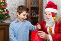 A shy child of several years receives a gift from Santa Claus.