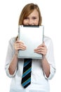 Shy girl hiding her face with a tablet device Royalty Free Stock Photo