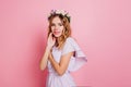 Shy girl in romantic summer outfit posing on pink background. Indoor portrait of spectacular woman with blonde shiny