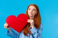 Shy and indecisive cute girl scared confess love, tell how she feels. Worried cute redhead teenager holding romantic Royalty Free Stock Photo