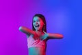 Little caucasian girl`s portrait isolated on gradient pink-blue background in neon light.