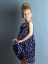 Shy little girl smiles against a gray background Royalty Free Stock Photo