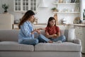 Shy little teenager girl turns away from smiling woman mother who is trying to communicate Royalty Free Stock Photo