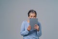 Shy mature woman hide holding digital tablet working or shopping online, checking on social media. Pretty grey haired Royalty Free Stock Photo