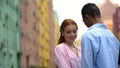 Shy red-haired girl cuddling to multiracial boyfriend, tender feelings, love