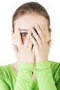 Shy or scared teenage girl peeking through covered face Royalty Free Stock Photo