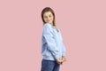 Shy teenage girl in a comfortable casual outfit posing isolated on a pink background Royalty Free Stock Photo