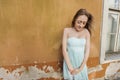 Shy teenage girl in tube dress standing against wall Royalty Free Stock Photo